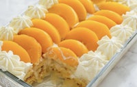 a dessert with peaches and cream in a glass dish