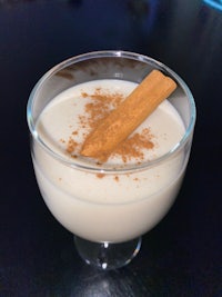 a glass of milk with cinnamon sticks in it