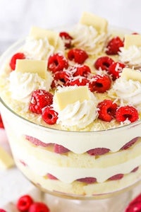 a trifle with raspberries and cream in a glass dish