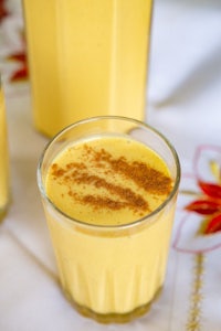 a glass of orange juice with cinnamon on top