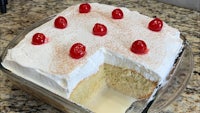 a slice of white cake with cherries on top