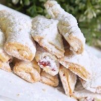 a plate of pastries with powdered sugar on it