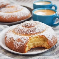 a plate with a cinnamon roll and a cup of coffee