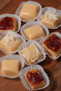 a group of chocolate covered caramels on a wooden table