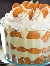 a trifle in a glass bowl with whipped cream